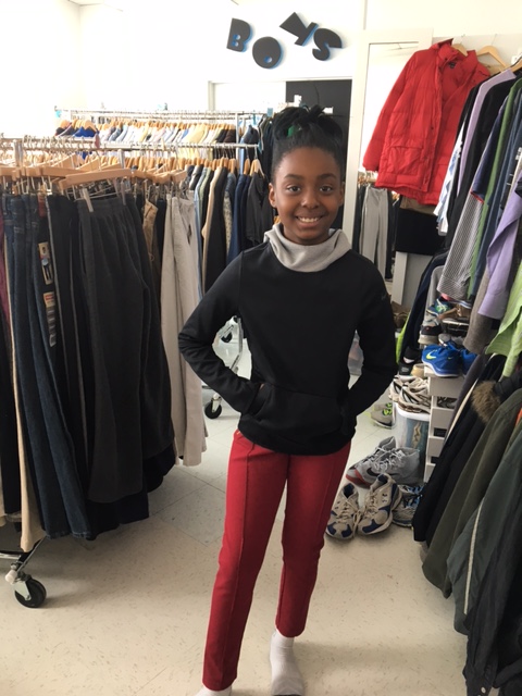 A happy child shopping for school clothing at Clothes To Kids of Fairfield County